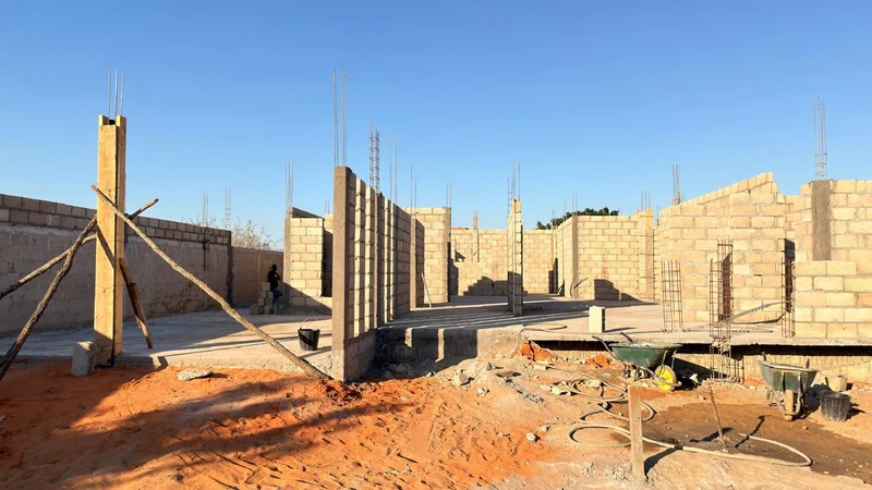 Vista ampla da obra com alvenaria e elementos estruturais